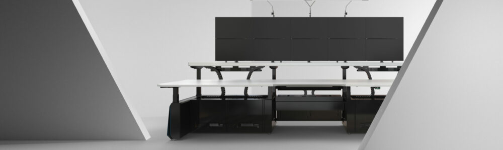 6m long desk with four large monitors mounted in a studio environment.