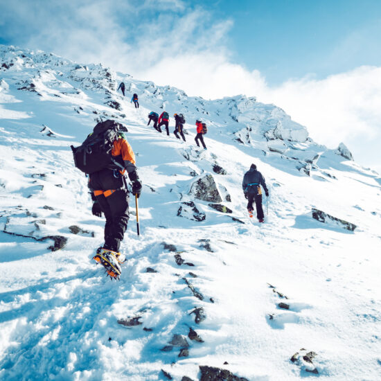 A group of climbers ascending a mountain in winter.